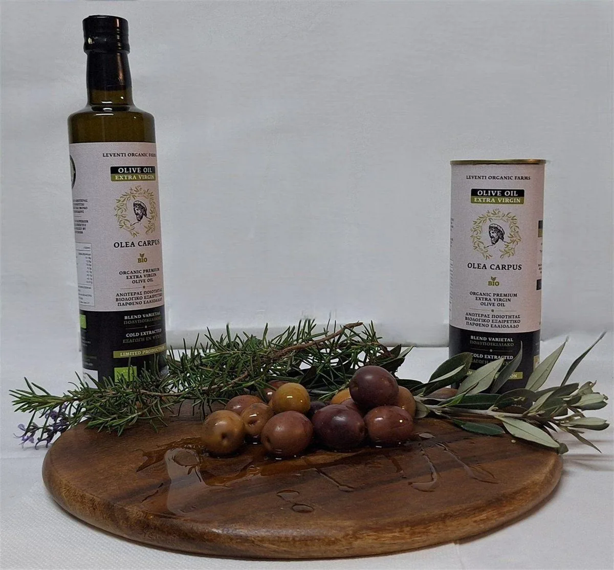 Μπουκάλι και μεταλλικό δοχείο 500ml Olea Carpus πάνω σε ξύλινη επιφάνεια με ελιές